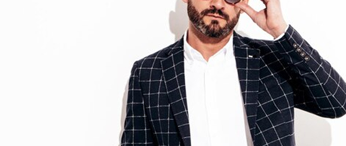 Мужчина в темном пиджаке в клеточку и светлой рубашке